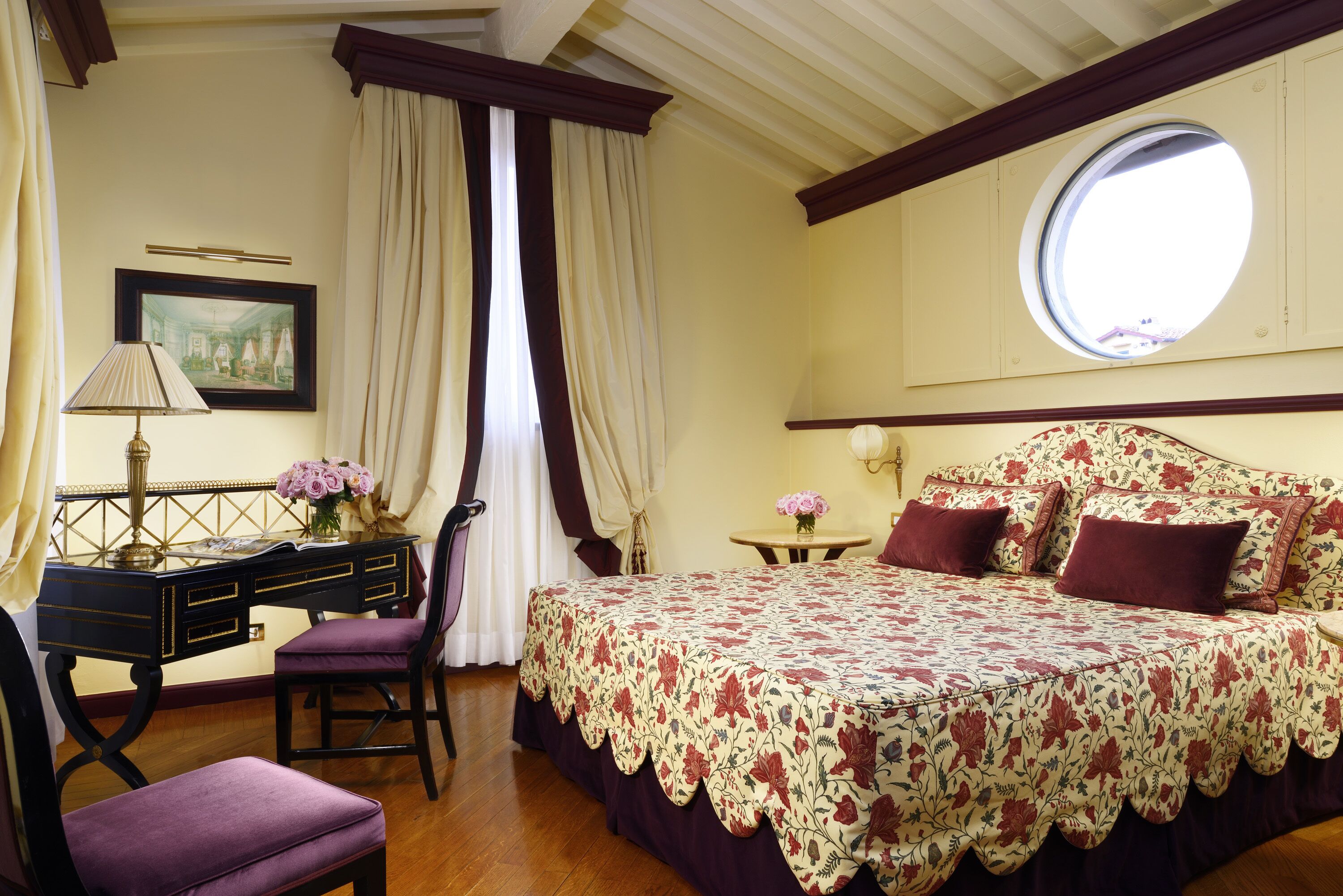 A bedroom with a bed, a desk, and a chair.