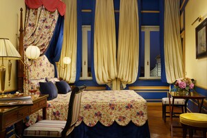 Una stanza con un letto, una scrivania, una sedia e una finestra con tende.