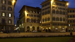 Un hotel con varios pisos, amplias ventanas y una entrada bien iluminada.
