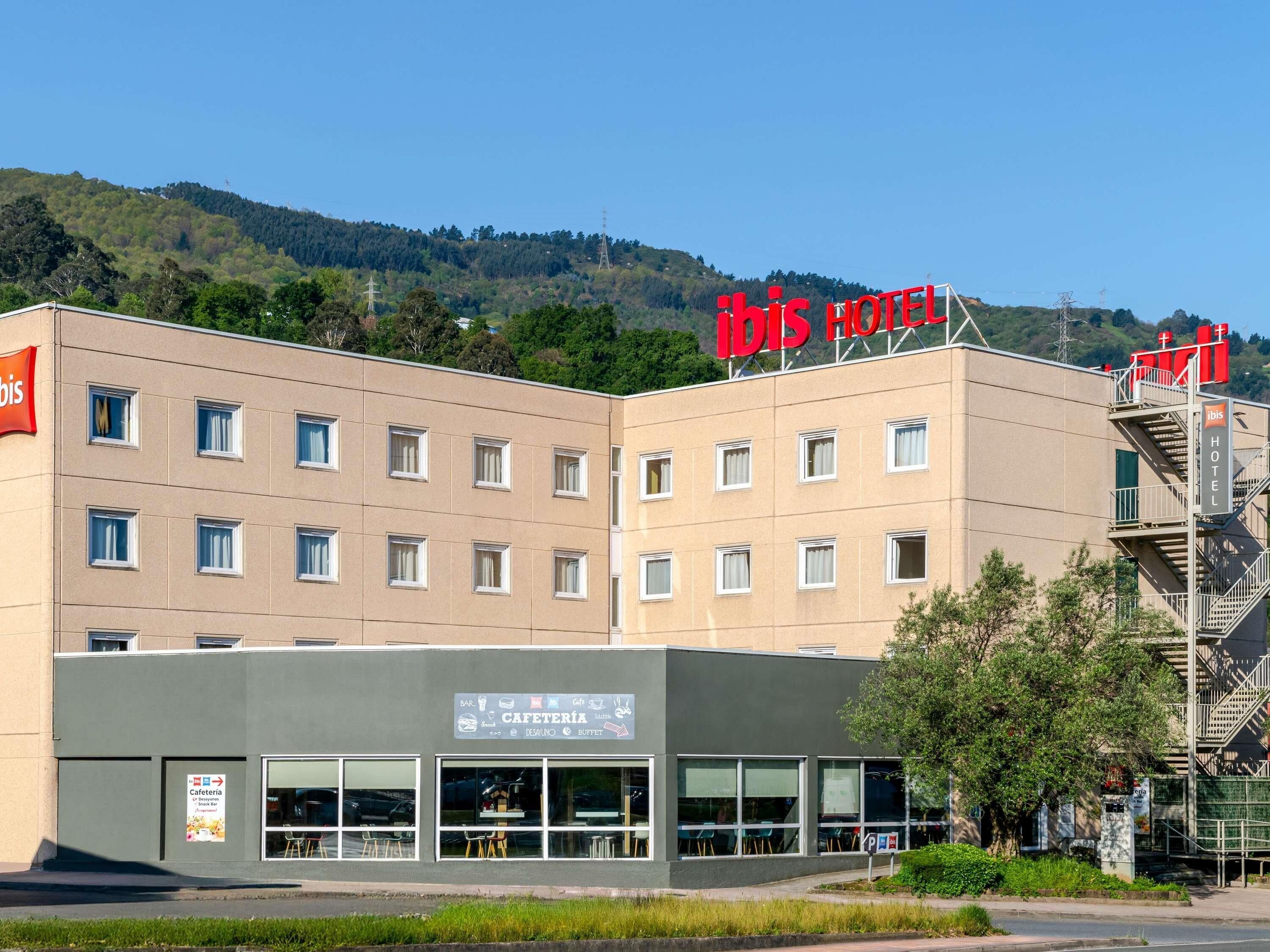 Een hotel met een bord waarop 'IBIS HOTEL' staat, en een café met een bord dat een bar, café en buffet aangeeft.