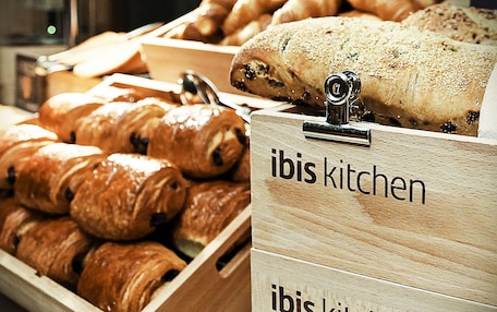 Wooden display cases labeled "ibis kitchen" containing various baked goods.