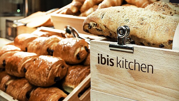 Wooden display cases labeled "ibis kitchen" containing various baked goods. - ibis Bilbao Barakaldo (Barakaldo)
