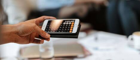 A person holding a smartphone with a numeric keypad.