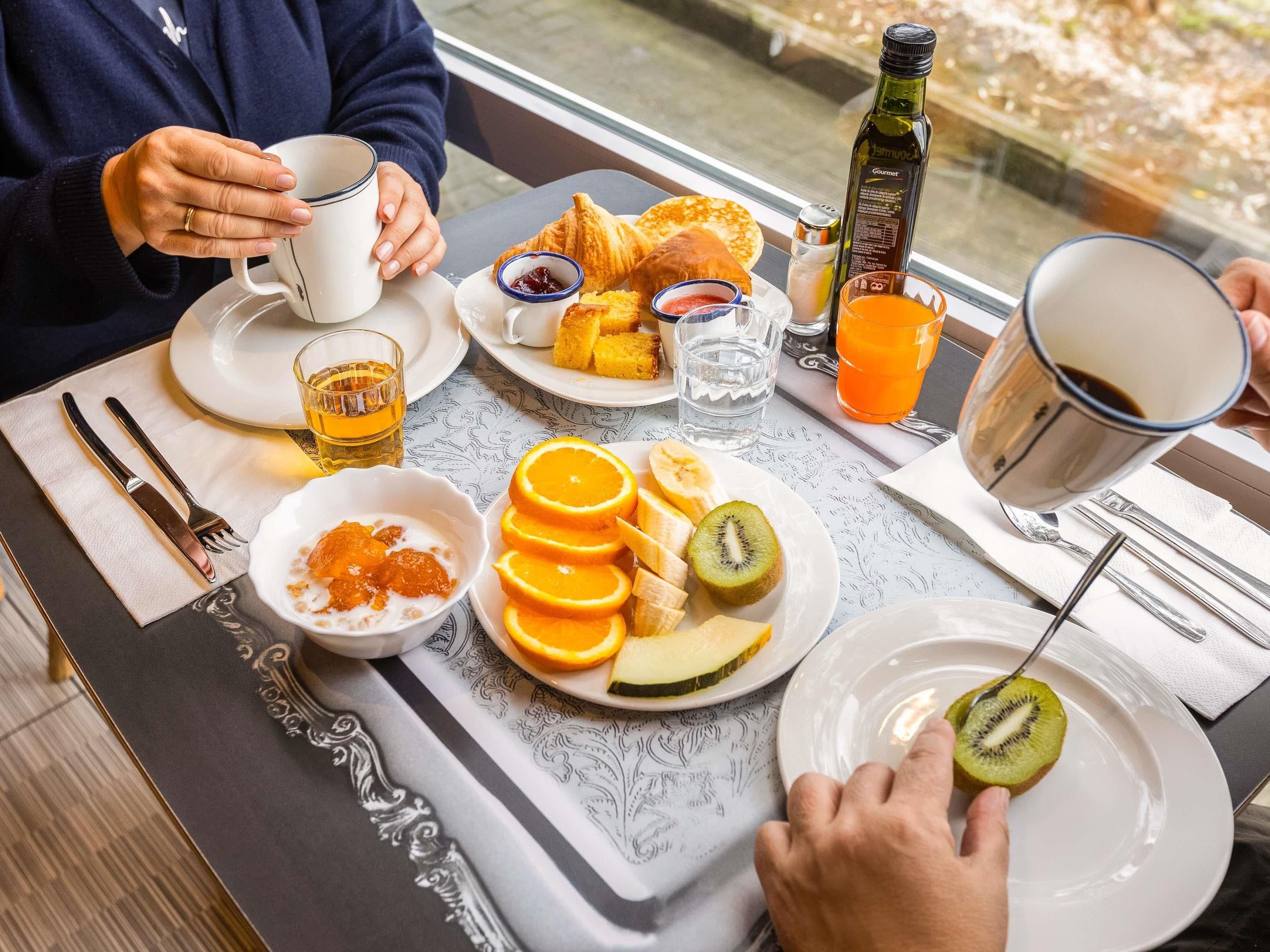 Een ontbijtsetting met borden eten, een fles en een kop.