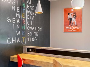 Una recepción con un muro de pizarra que muestra palabras como 'BUSINESS', 'INTERFACE' y 'WEB'.