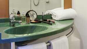 A bathroom with a glass-enclosed shower, a green sink, and a mirror. - ibis Bilbao Barakaldo (Barakaldo)