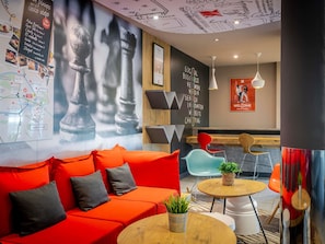 Um interior moderno com um sofá vermelho, um mapa na parede e um letreiro com a inscrição 'Social Business'.