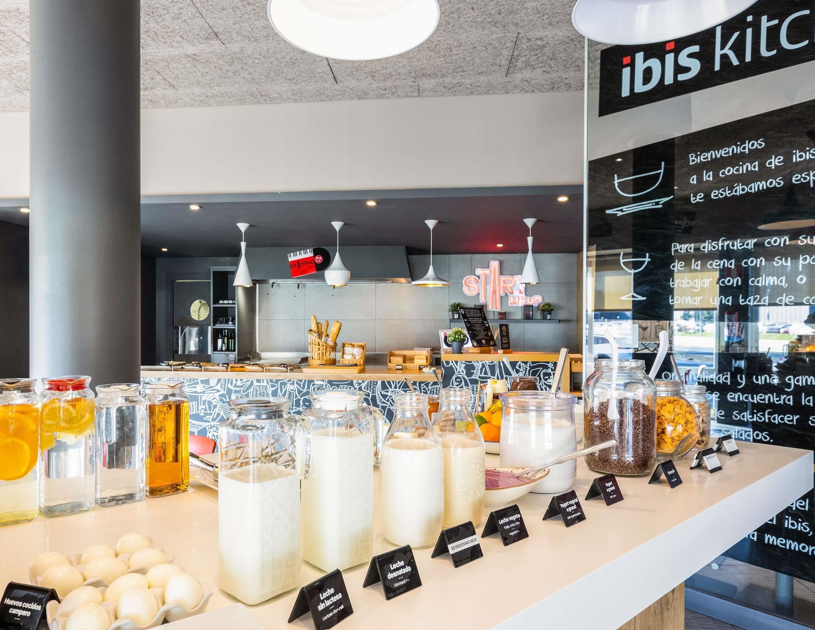 A cafe interior with a counter displaying various food items and drinks.