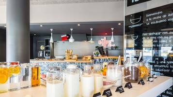 A cafe interior with a counter displaying various food items and drinks.