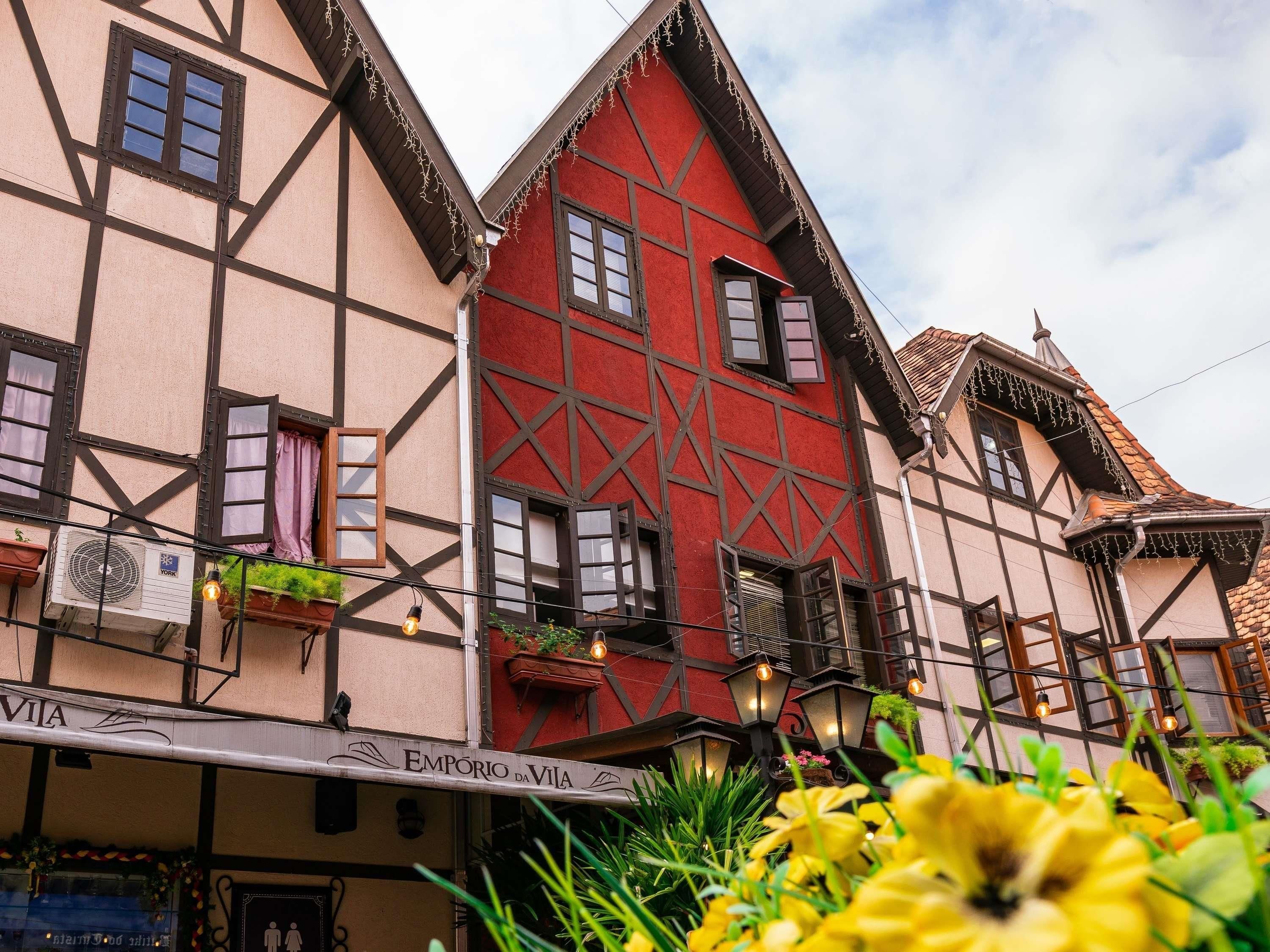 Un bâtiment traditionnel à colombages, doté d’une façade rouge et de nombreuses fenêtres, dont une boutique dont l’enseigne est visible.