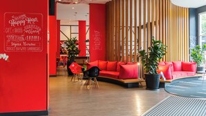 A modern interior with a red wall, wooden slats, and a red sofa. - ibis Blumenau (Blumenau)