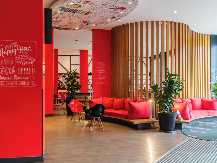 Un intérieur moderne avec un mur rouge, des lambris en bois et un canapé rouge.