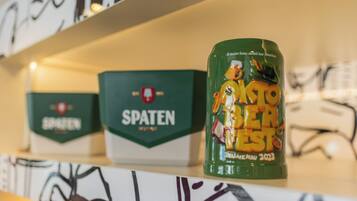 Ein Regal mit Kisten mit dem Aufdruck 'SPATEN' und einem Behälter mit der Aufschrift 'KOTTO BIER' und 'HERAUSFORDERUNG 2023'.