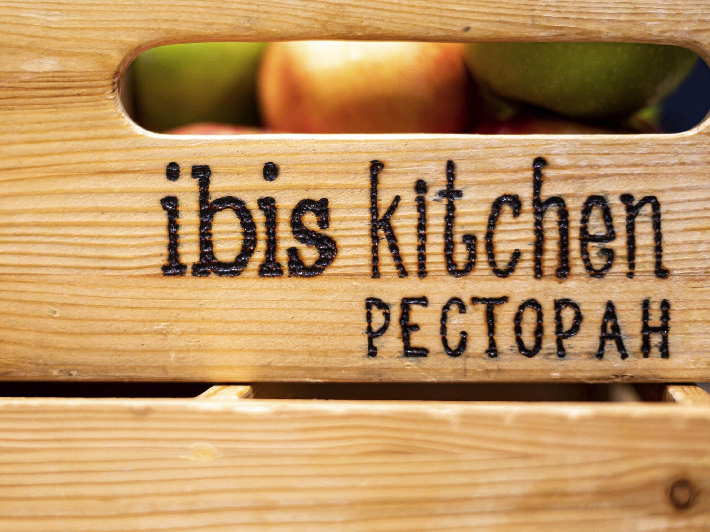Ein Holzschild mit dem Text 'ibis kitchen PECTOPAH'.