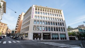 Ett hotell med flera våningar, en modern fasad, stora fönster och en framträdande entré.