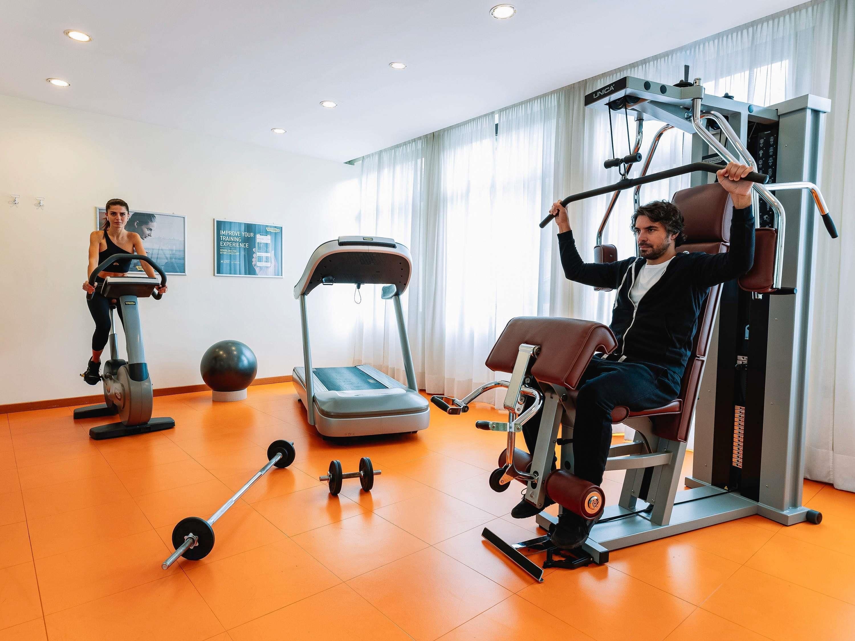 A gym with treadmills, a stair climber, and weightlifting equipment.
