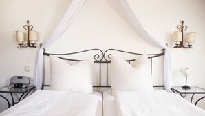 A double bed with white linens, a canopy, and two bedside tables with lamps. - Hotel Laimer Hof Nymphenburg Palace Munich (Munich)