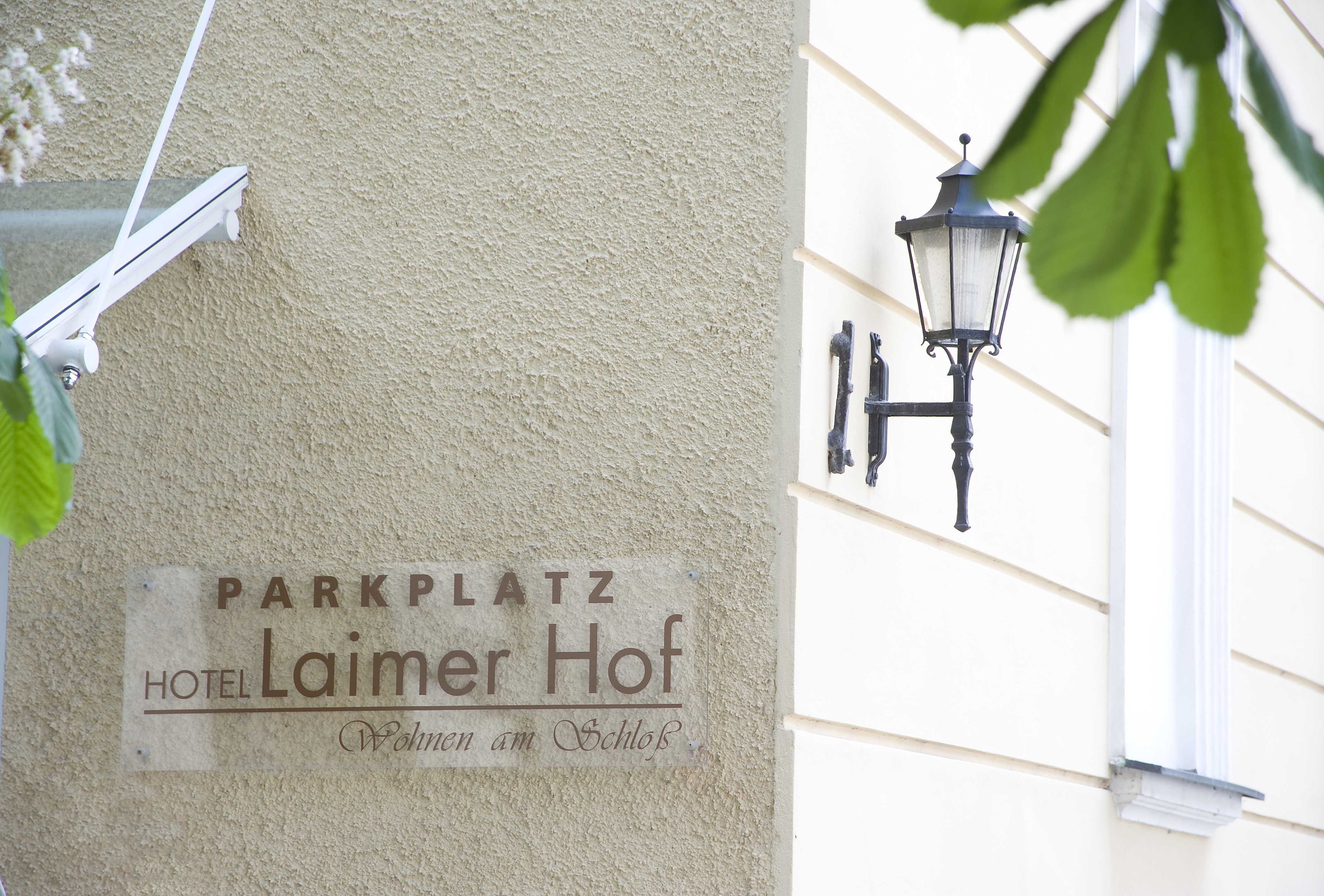 Un panneau indiquant « Parkplatz Hotel Laimer Hof » avec un lampadaire à proximité.