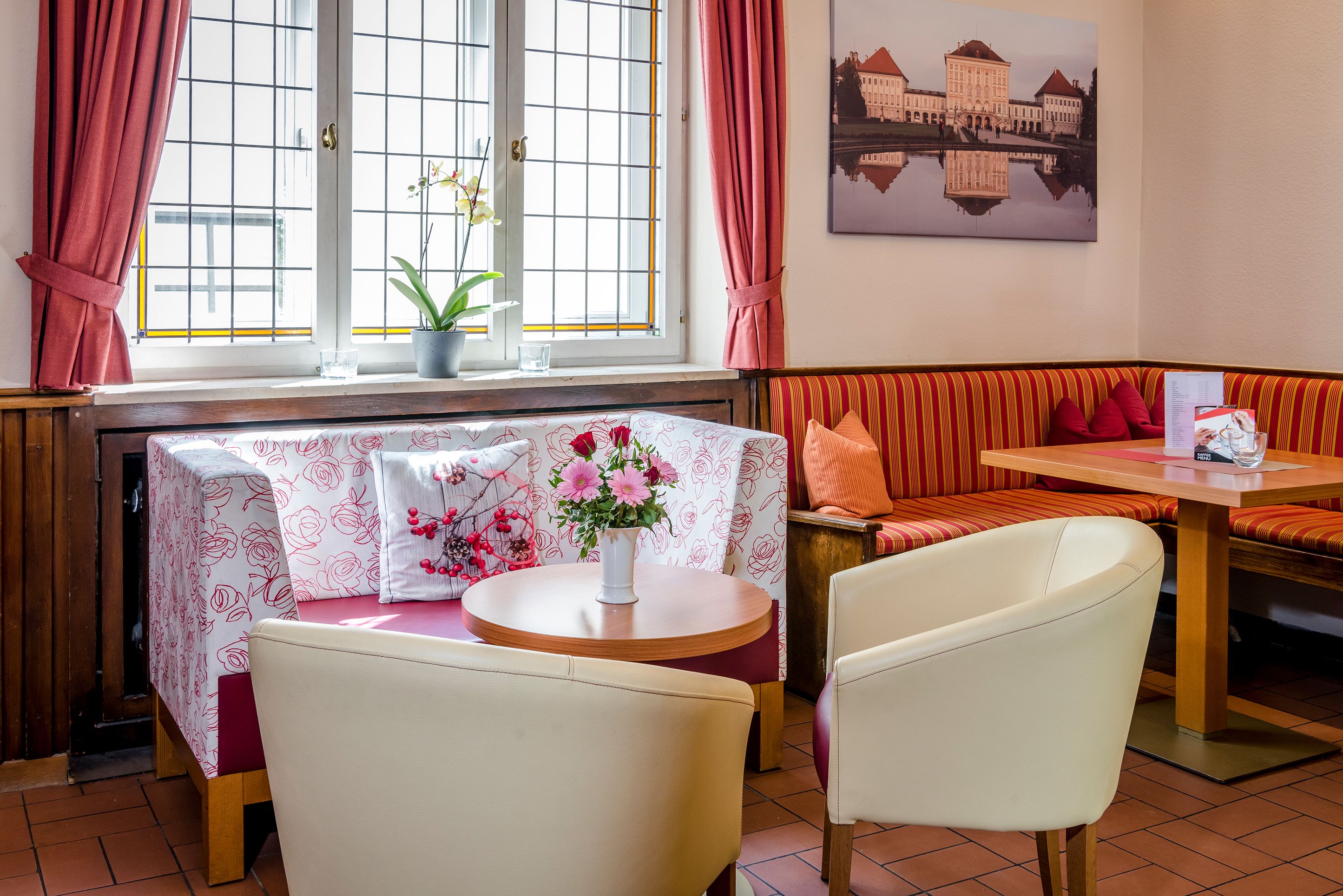 Une pièce chaleureuse avec une table à manger, un banc et une fenêtre avec des rideaux.