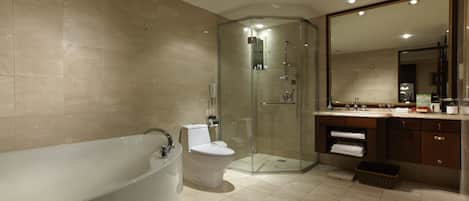 Un baño moderno con ducha de vidrio, bañera independiente y tocador con espejo.