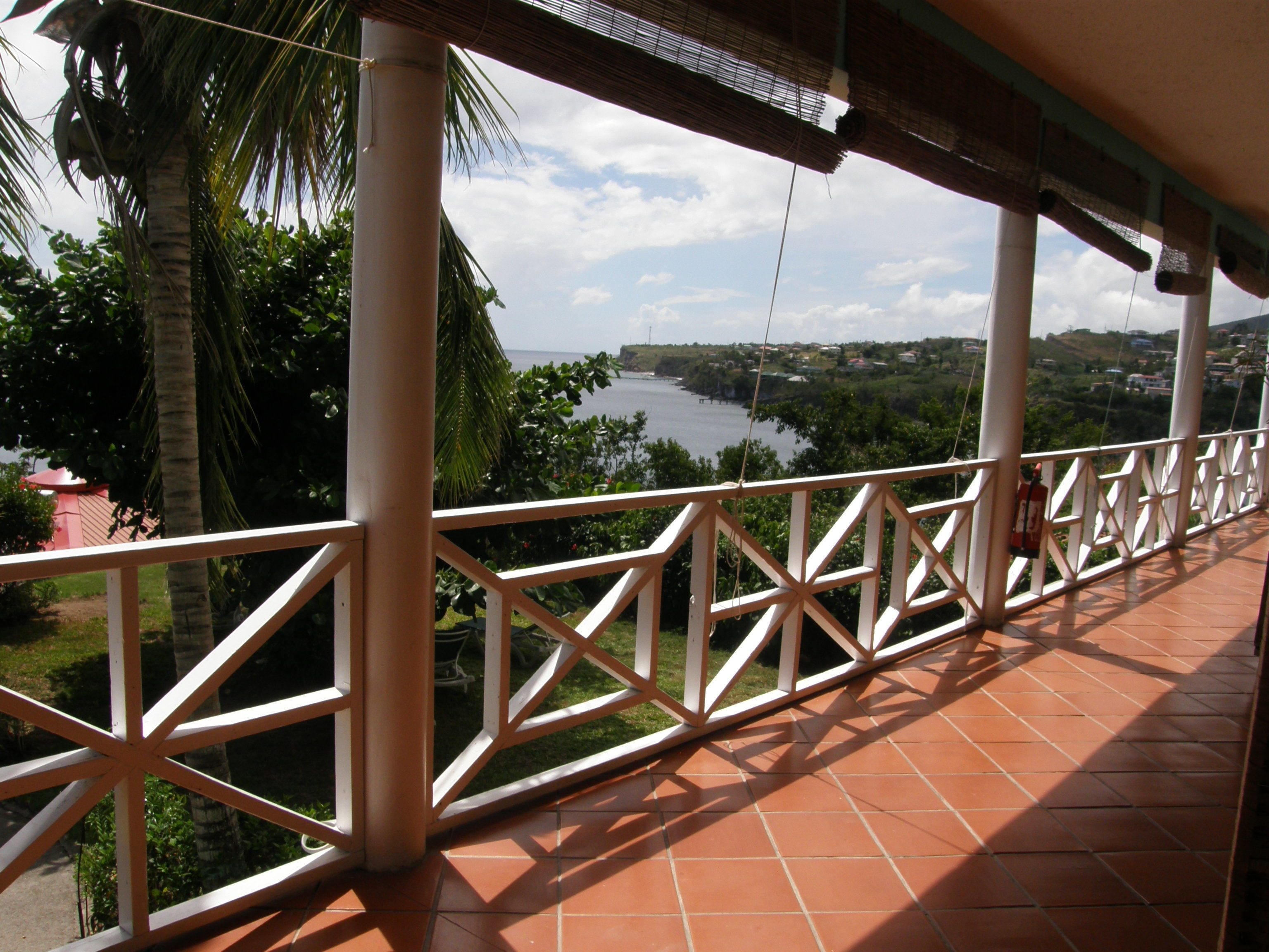 A balcony with a view of a river and surrounding greenery.
