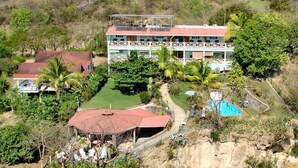 A two-story building with a red roof, surrounded by lush greenery and a swimming pool. - Tamarind Tree Hotel and Restaurant (Salisbury)