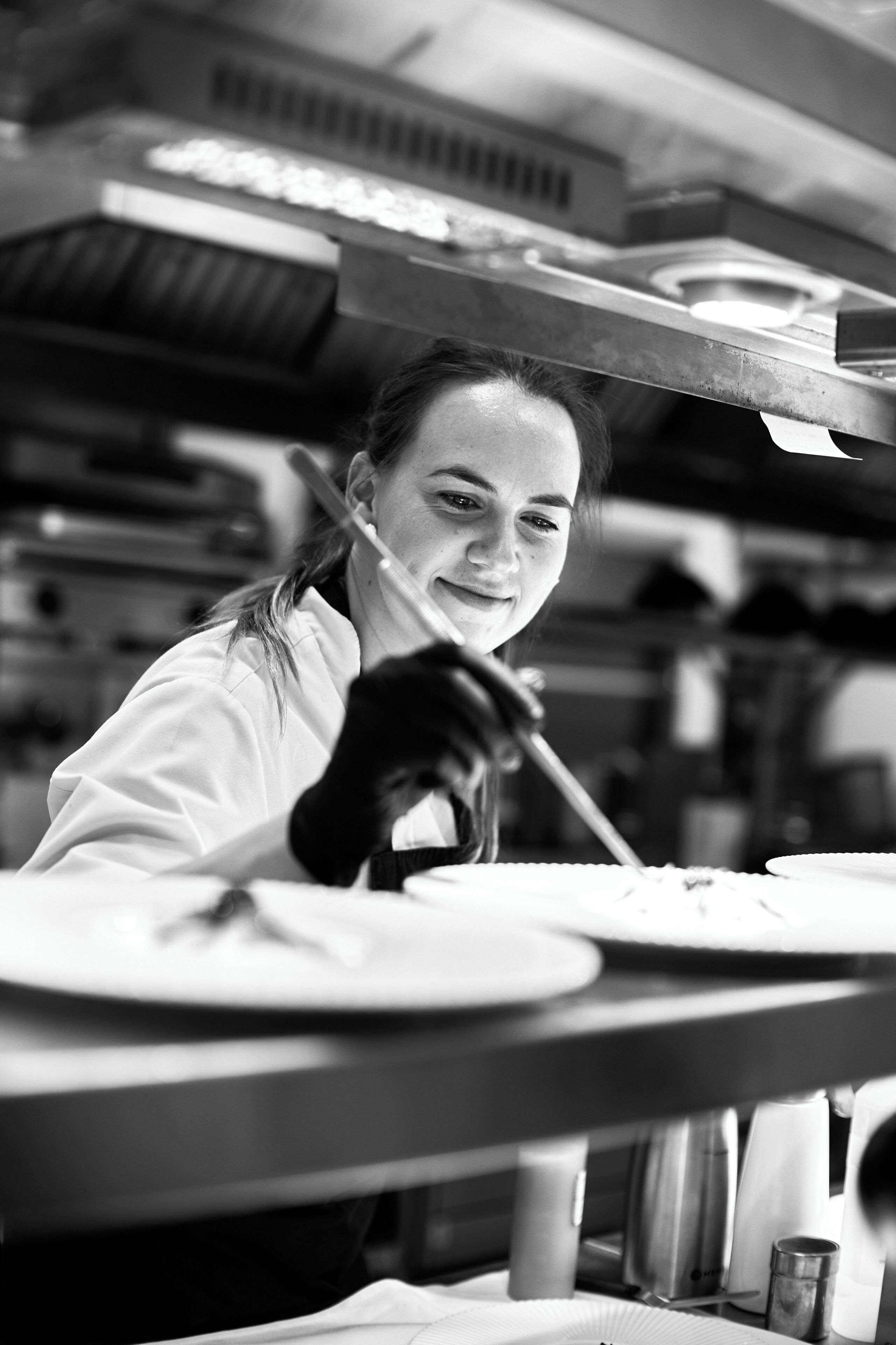 A person working at a kitchen counter with a focus on the stove and utensils.