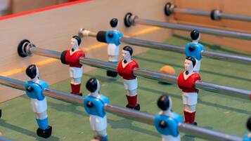 Una mesa de futbolín con jugadores con uniformes rojos y azules.