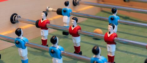 A tabletop foosball table with players in red and blue uniforms.