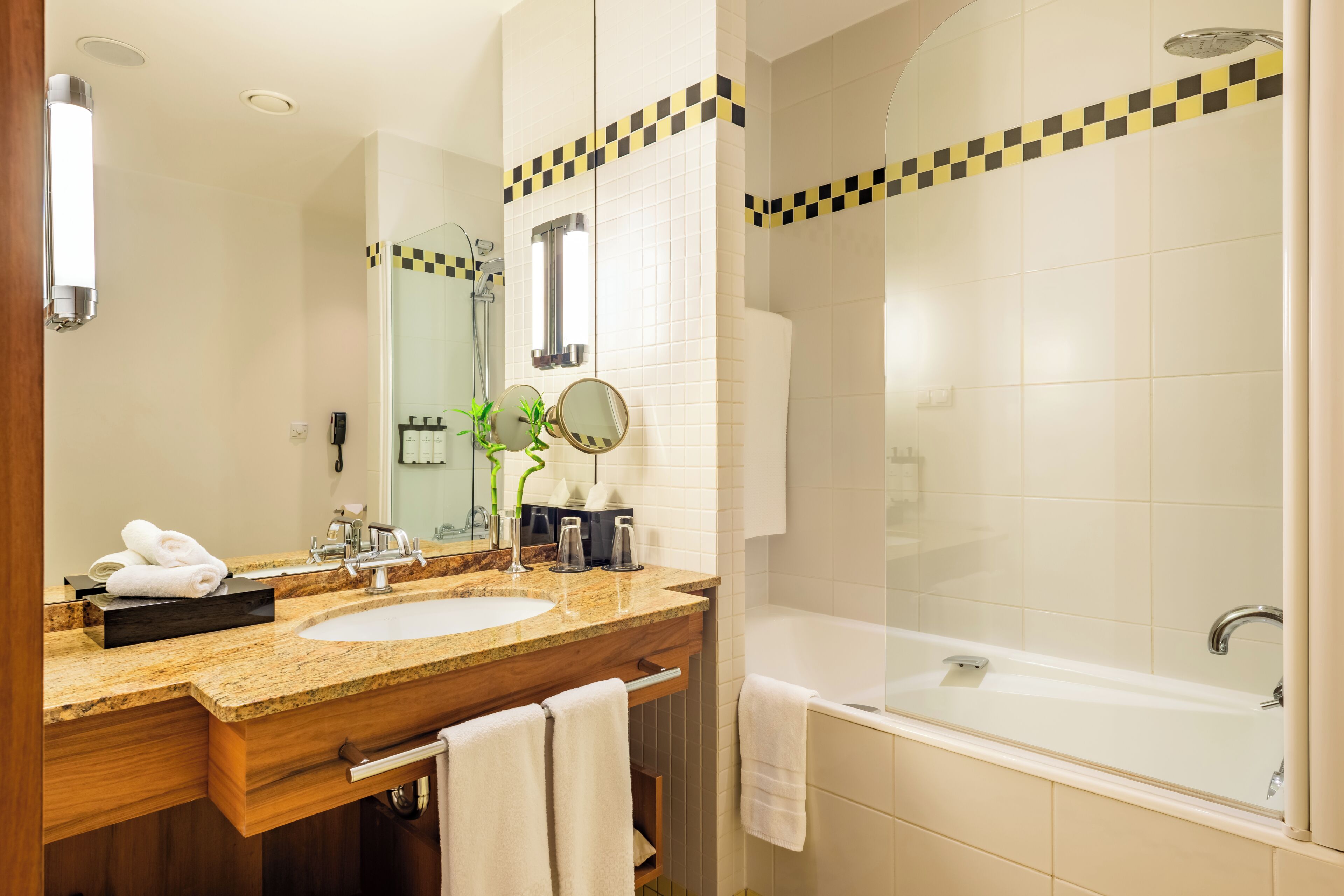 Un baño con dos lavabos, una bañera y un espejo.
