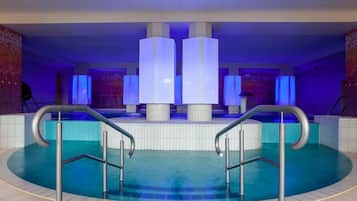 Una piscina techada, sillones reclinables de piscina