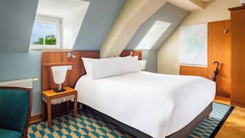 Un dormitorio con una cama grande, una mesita de noche, una silla, un ventanal y un armario de madera.