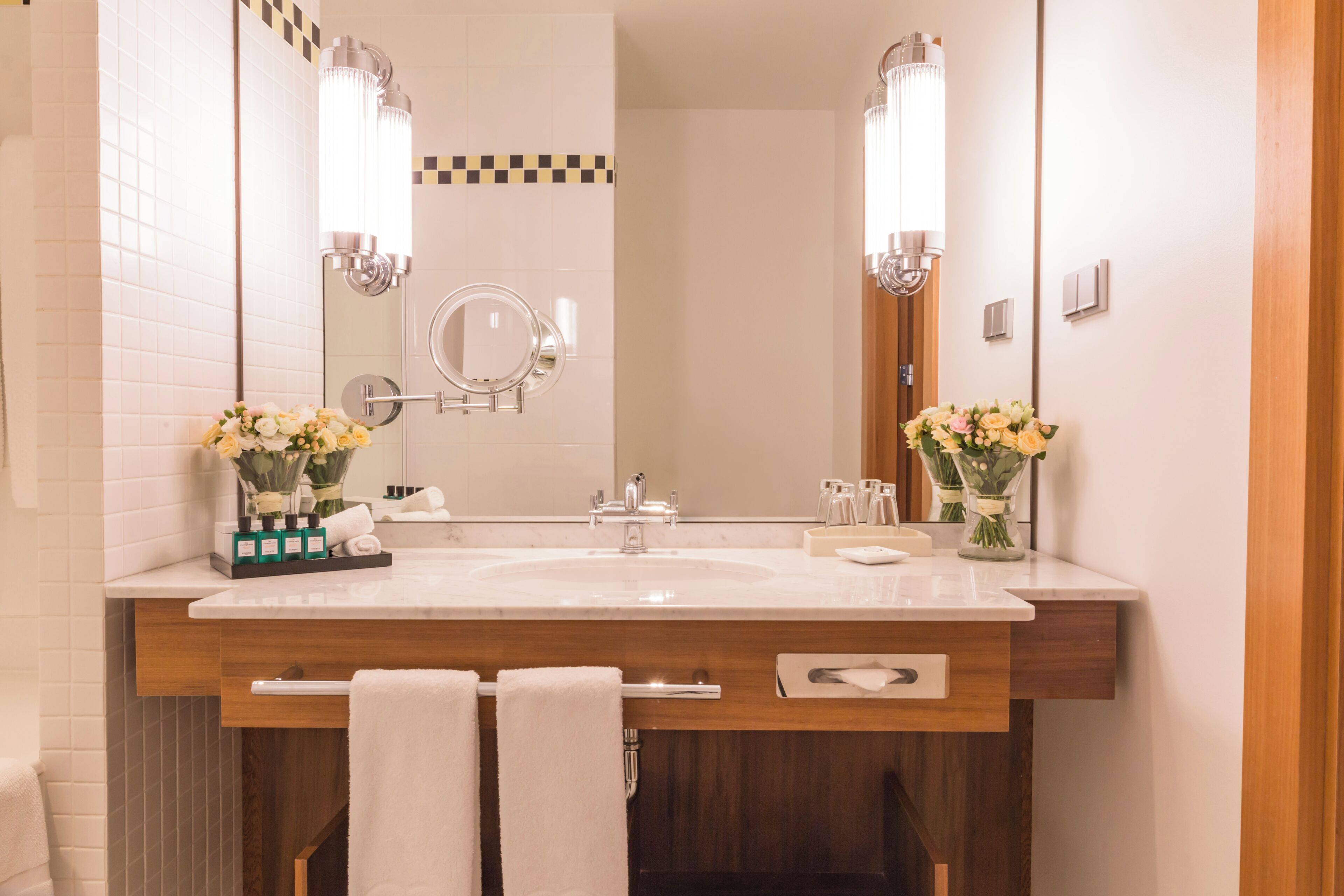 A bathroom with a double sink, two mirrors, and a wooden vanity.