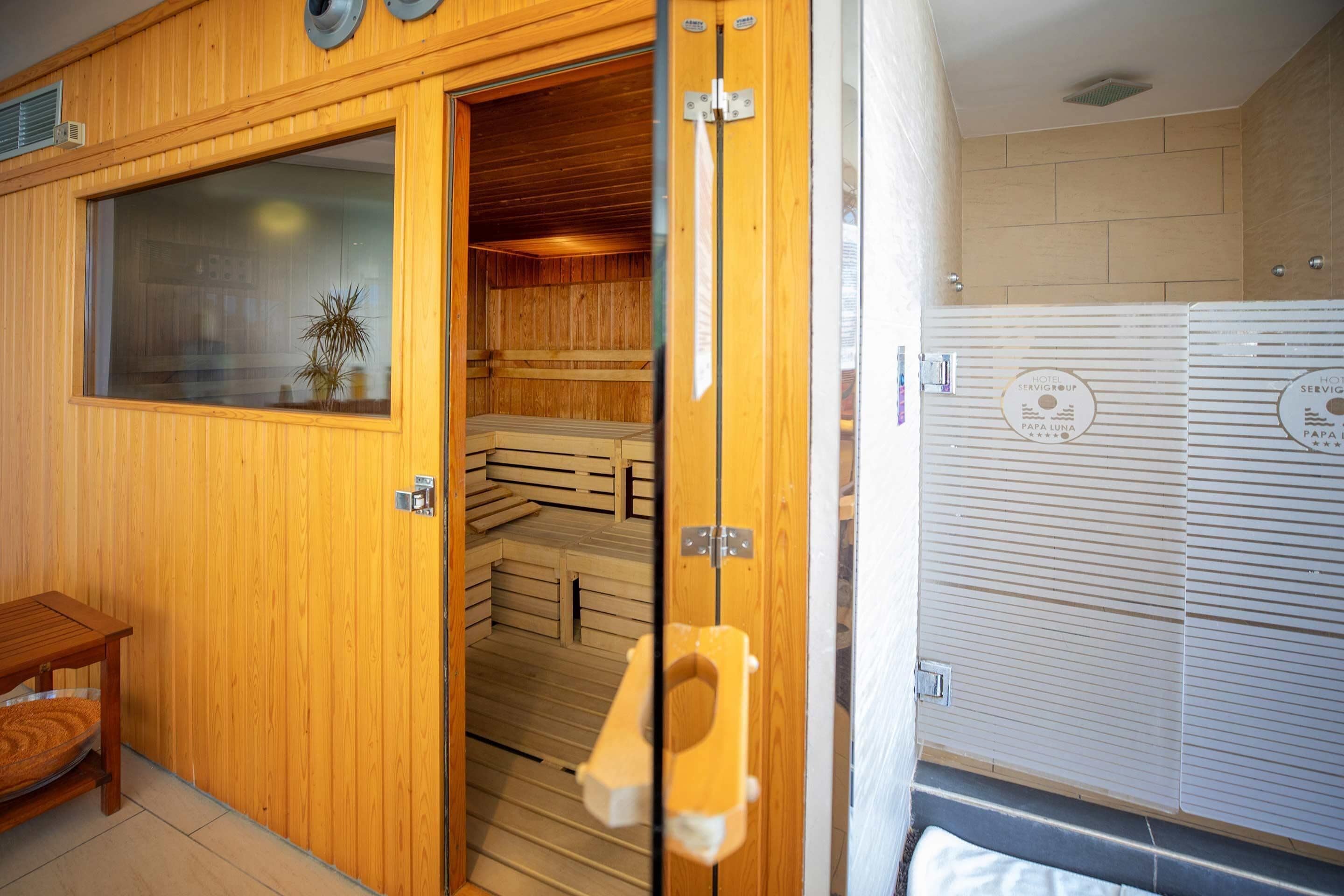 Een houten sauna met een houten bank en een raam.