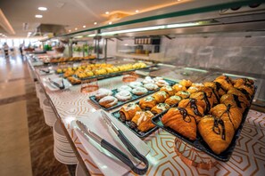 Un bufé con diversas opciones de pastelería y productos horneados.