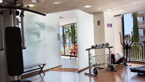A gym with exercise equipment, a bench, and a view of the outdoors.