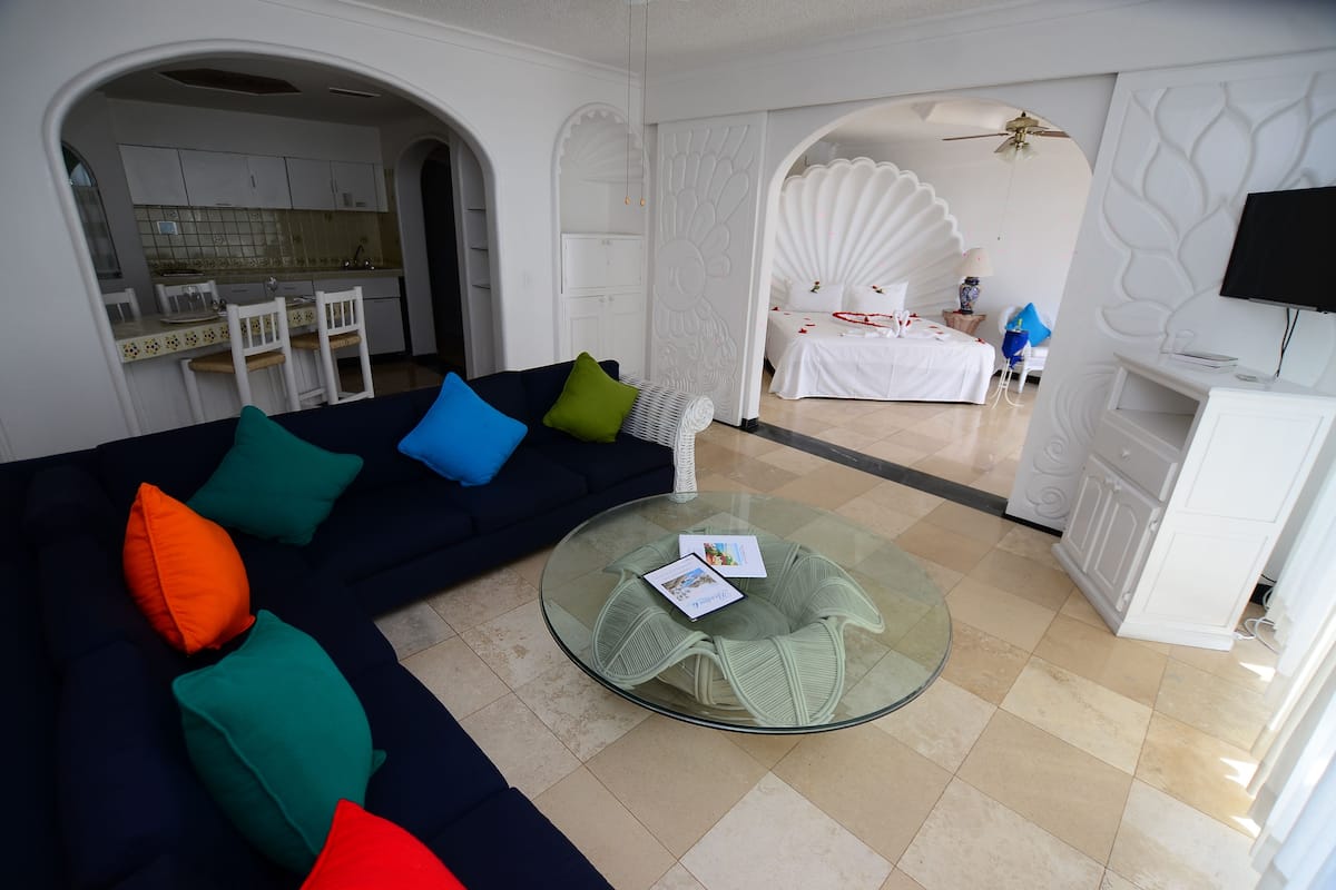 Deluxe One Bedroom Suite | Living area | 21-inch TV with cable channels