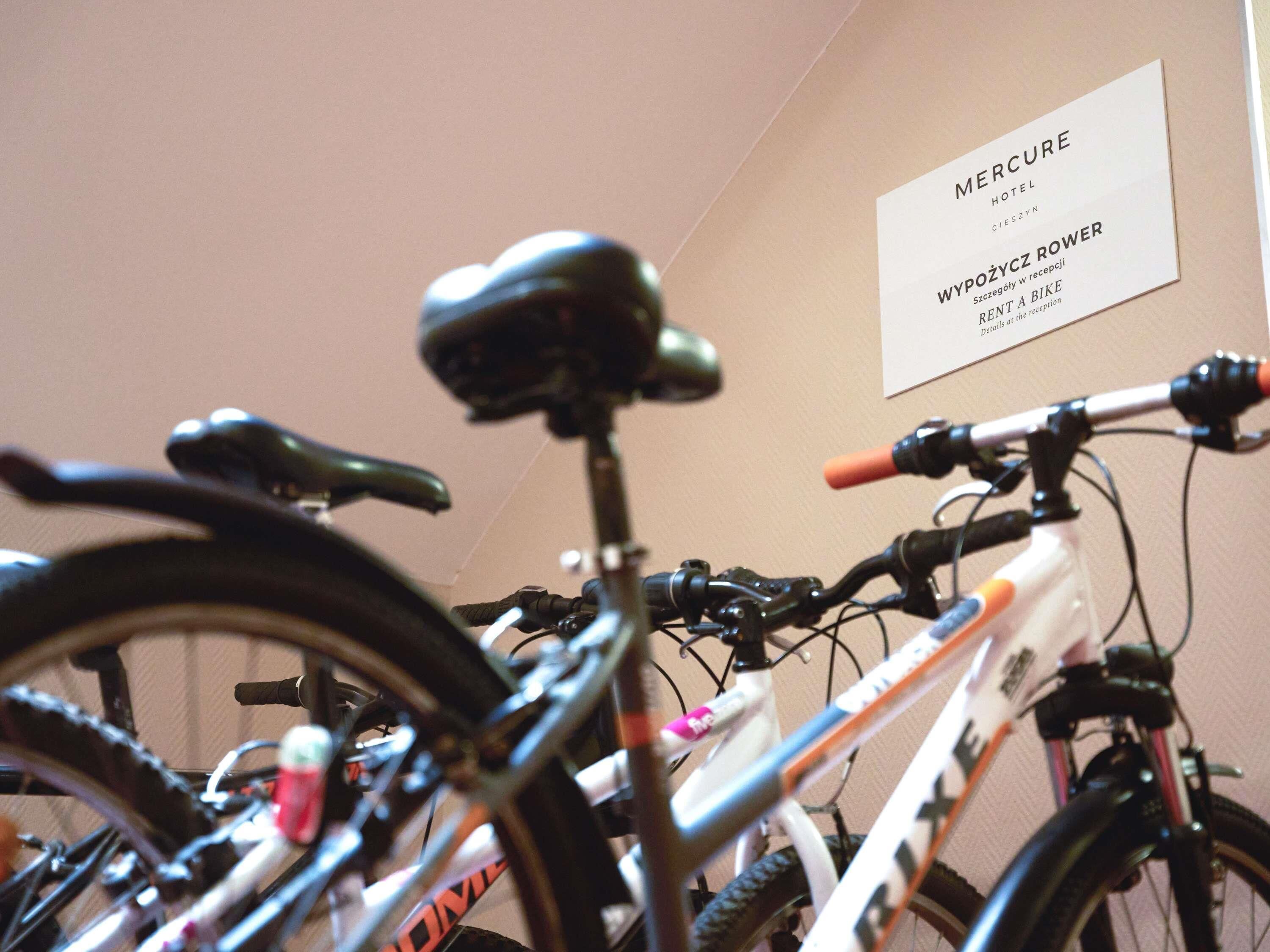 A bicycle with a black seat and handlebars, a white frame, and a pink water bottle.
