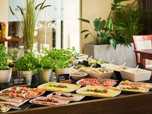 A buffet with various cold cuts, cheeses, and salads.