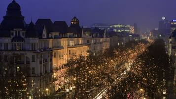 Un paisaje urbano nocturno con edificios e iluminación en árboles.
