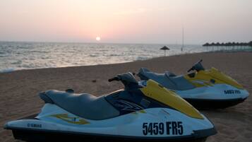 Due jet ski Yamaha su una spiaggia con il tramonto sullo sfondo.