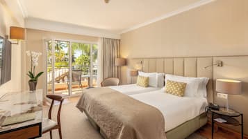Ein Hotelzimmer mit Bett, Schreibtisch, Stuhl, Lampe und Blick ins Freie.