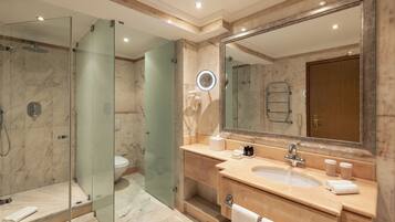 Un bagno moderno con doccia vetrata, un ampio specchio e un mobile lavabo con lavandino e porta asciugamani.