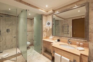 Un bagno moderno con doccia vetrata, un ampio specchio e un mobile lavabo con lavandino e porta asciugamani.