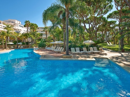 Outdoor pool, pool umbrellas, sun loungers. Ria Park Garden Hotel