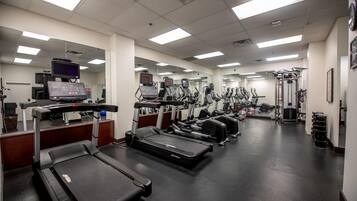 Gimnasio con cintas de correr, elípticas y equipos de pesas.