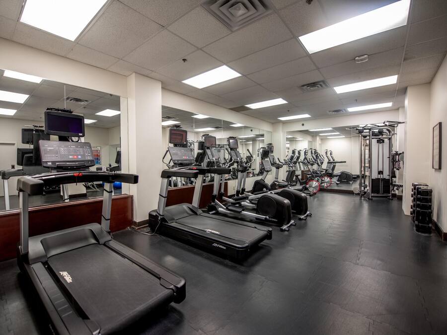 Gimnasio con cintas de correr, elípticas y equipos de pesas.