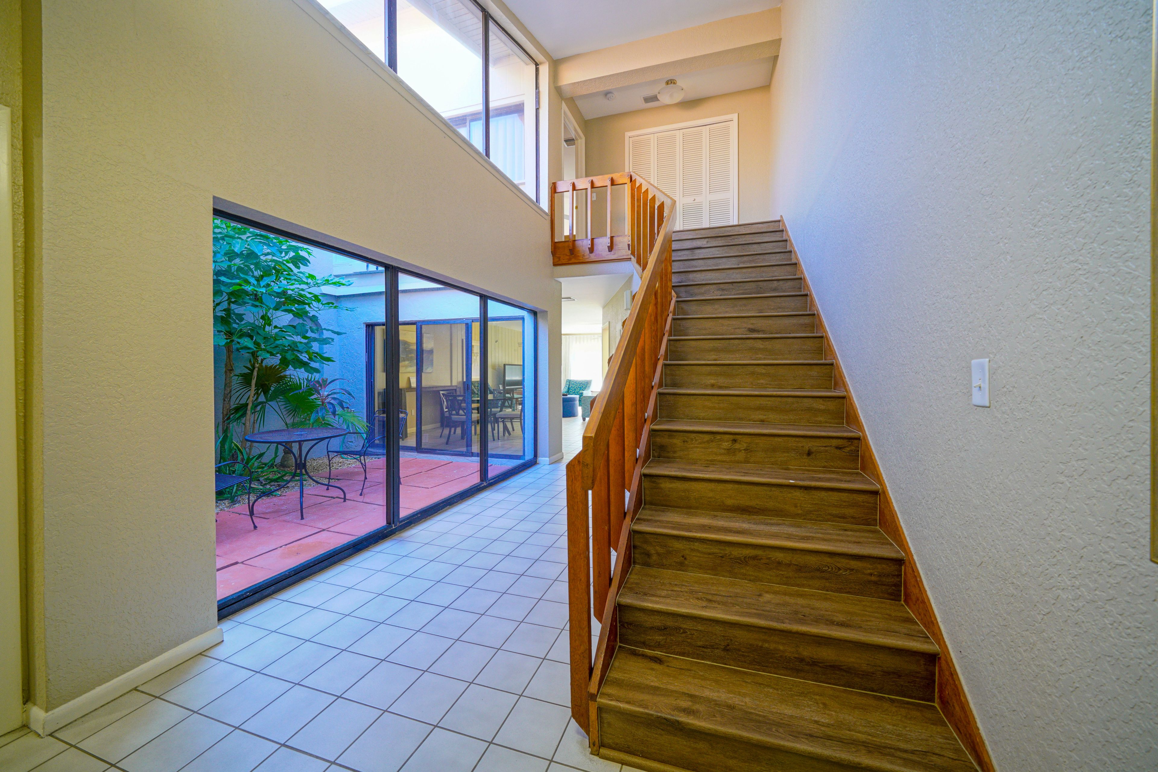 A staircase leading to an upper floor with a view of a patio area.