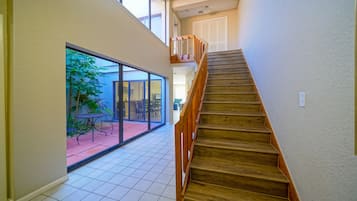 A staircase leading to an upper floor with a view of a patio area.