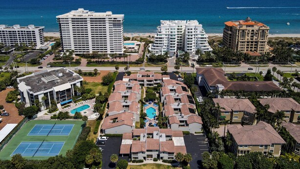 A resort with multiple buildings, a central pool, tennis courts, and a beach view. - Ventura at Boca Raton (Boca Raton)